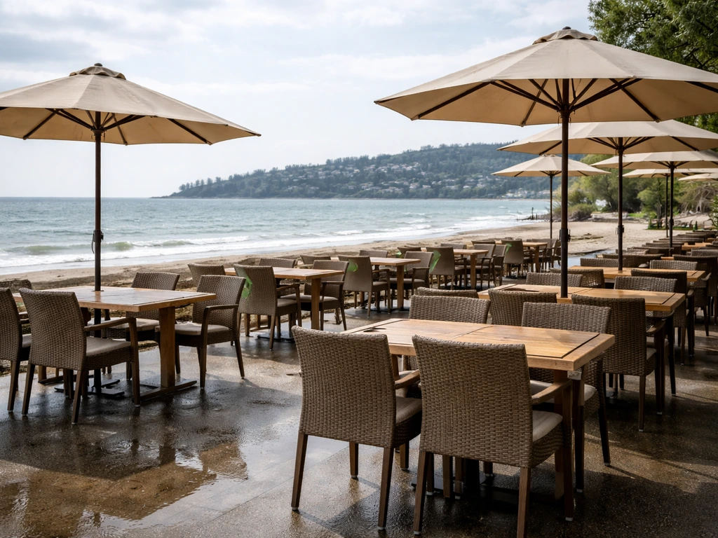 Outdoor patio seating at Earls Kitchen + Bar, Ambleside Beach, with chairs and umbrellas facing the ocean.