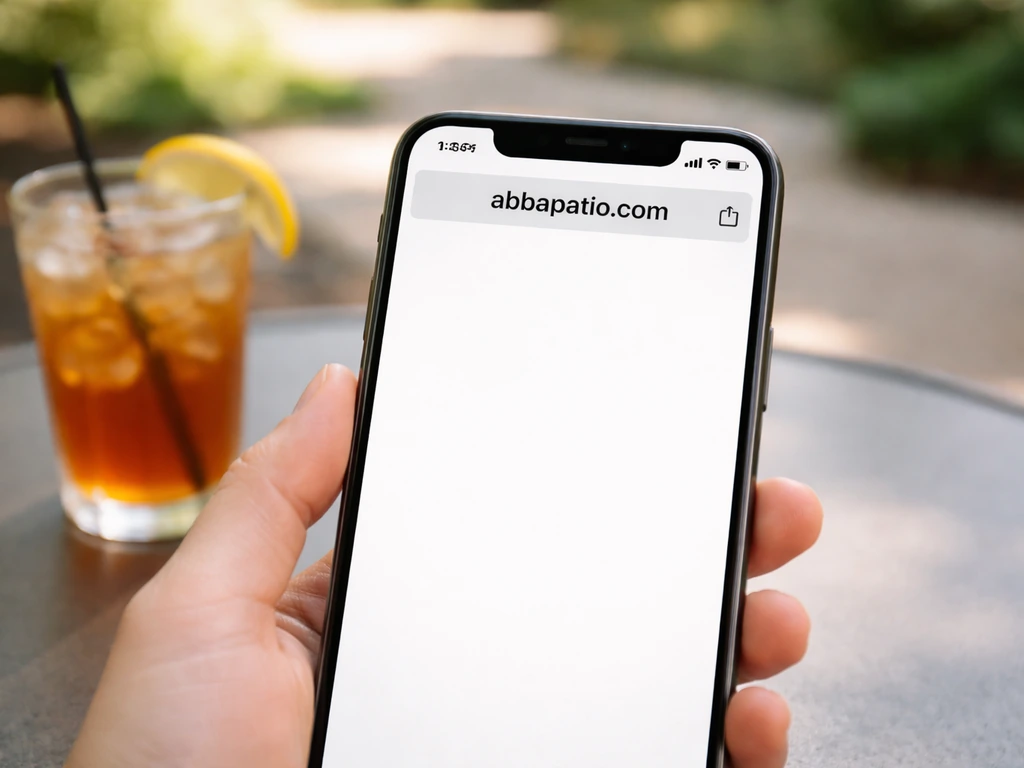 Close-up of a smartphone displaying the URL abbapatio.com on a patio table.