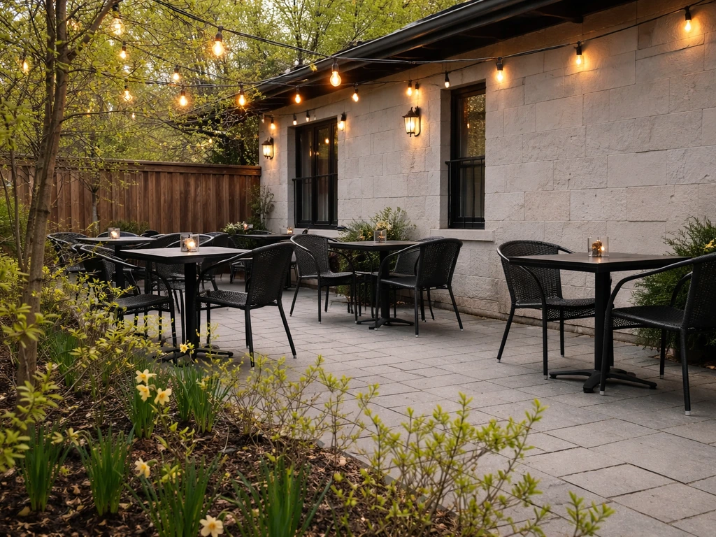Empty Ontario restaurant patio with spring greenery and set outdoor tables in early season sunlight.